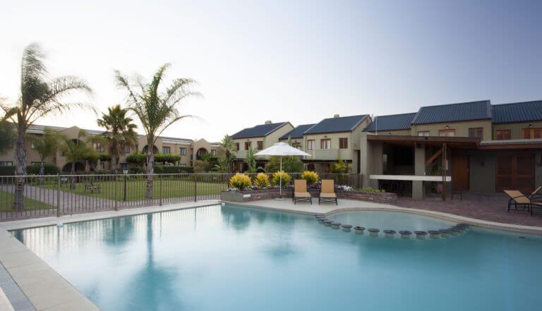 Outdoor pool stands between Estate accommodation