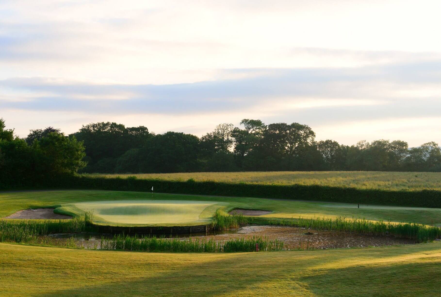 Island green protected by water and bunkers in Wales