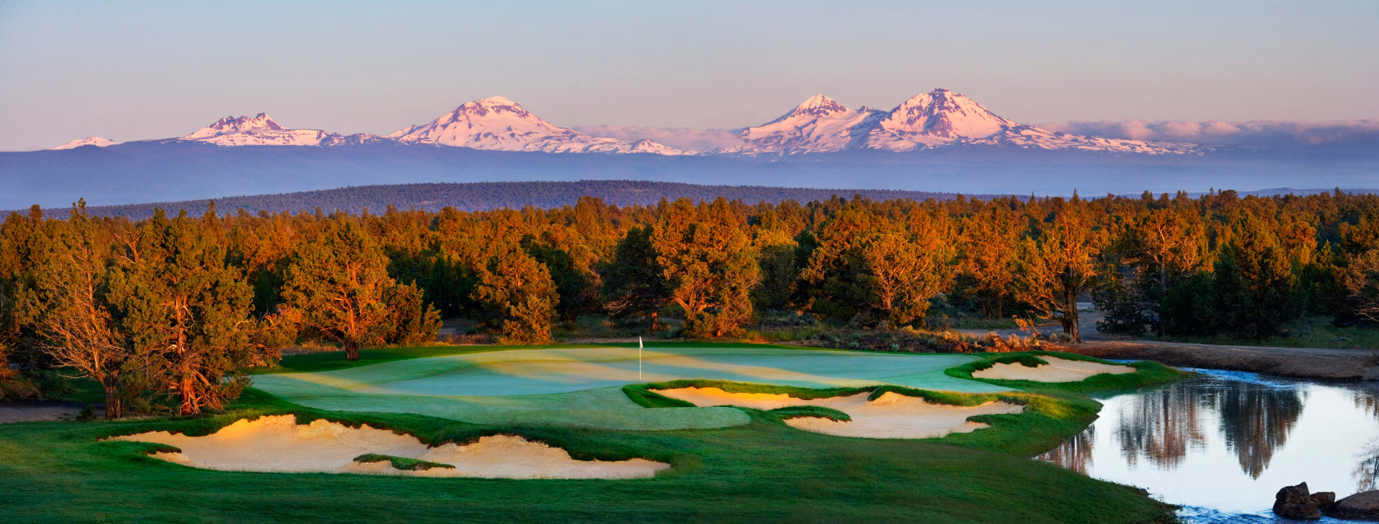Setting sun casts pink light on Pronghorn Resort and nearby mountains