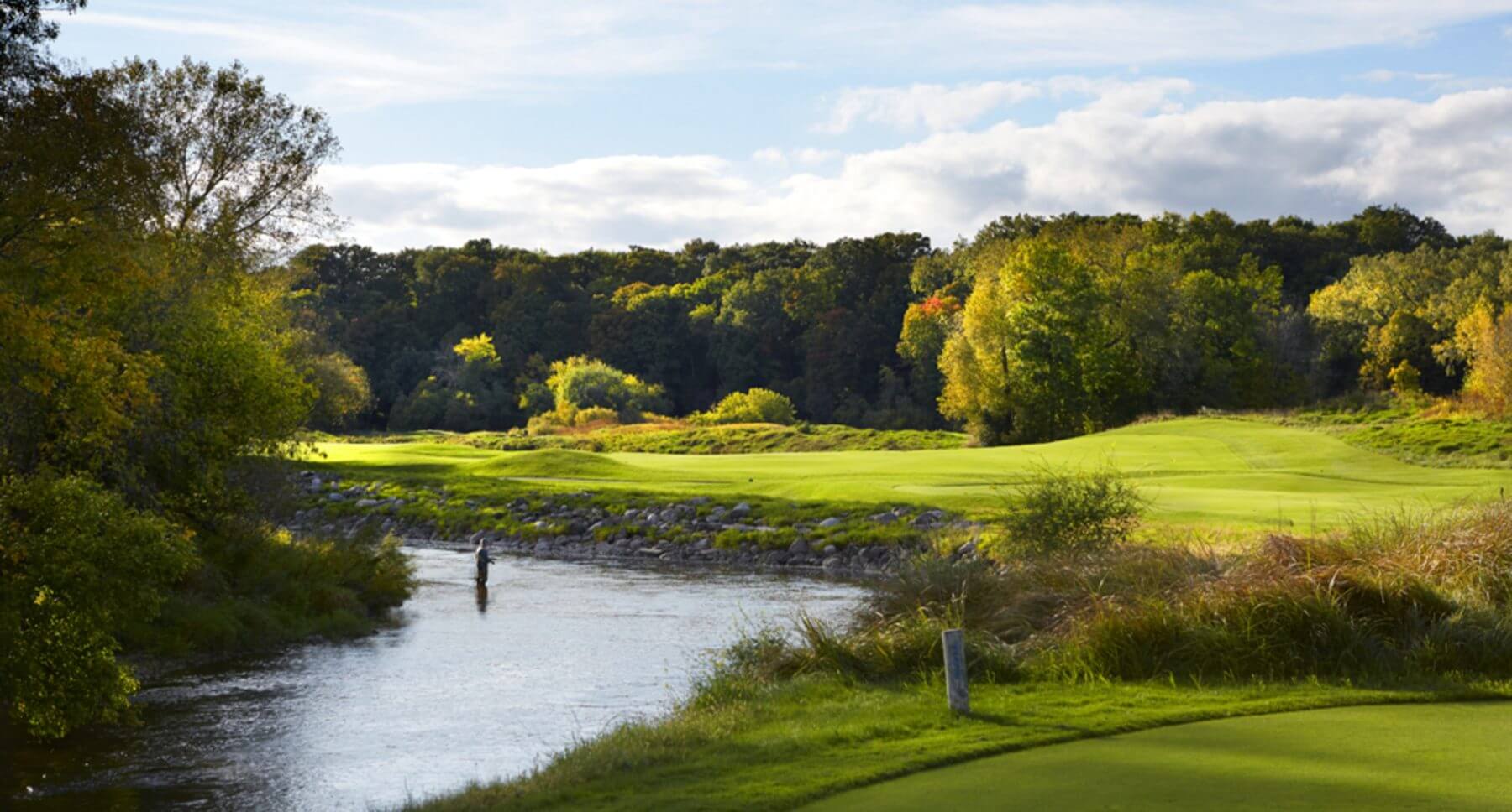 Man fishes in river next to Kohler golf club