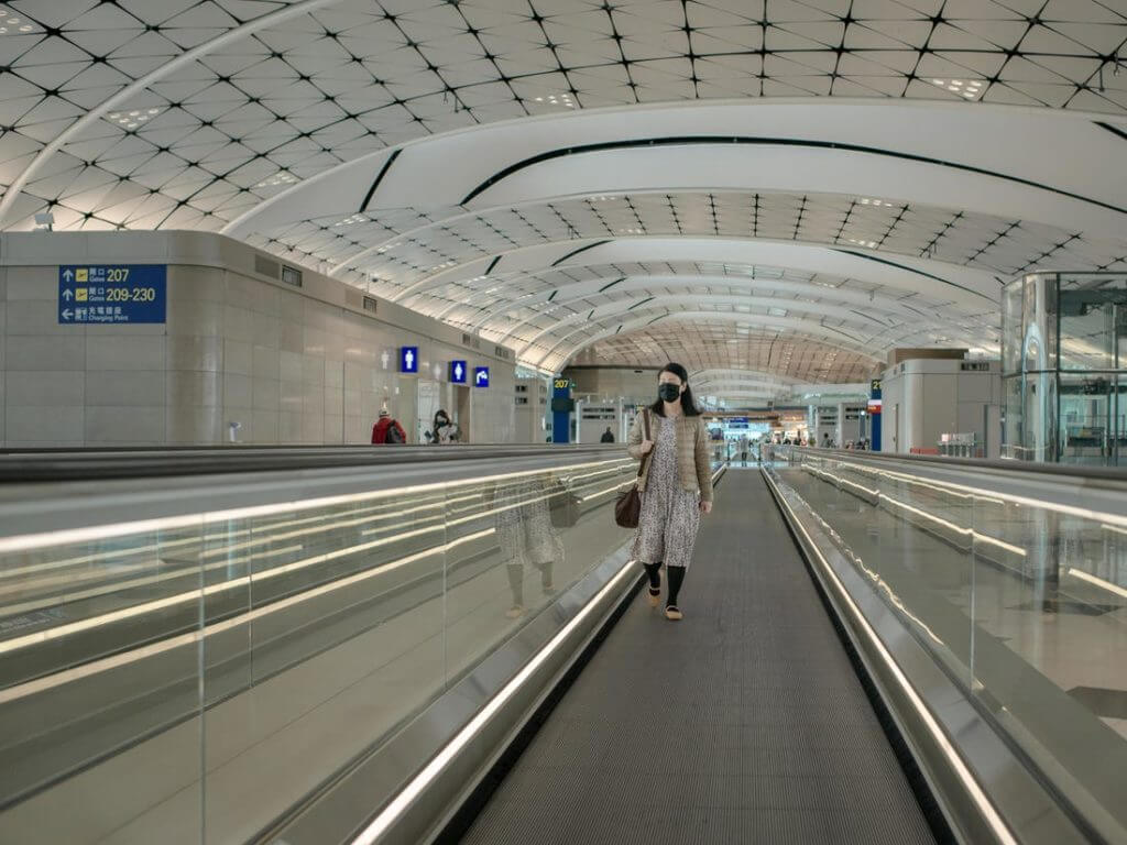 Woman in face mask in empty airport terminal
