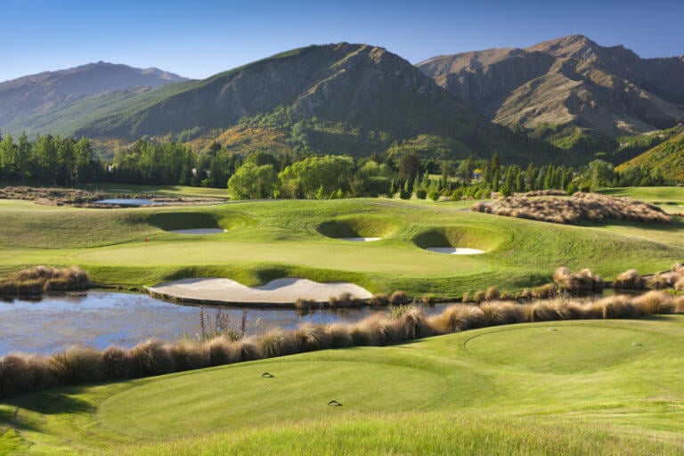 Dragonfly lake resides between the fifth and sixth golf holes with mountains behind