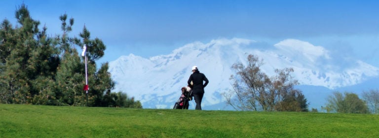 Golfer standing on Taupo Tauhara golf course with distant snowcapped mountain views