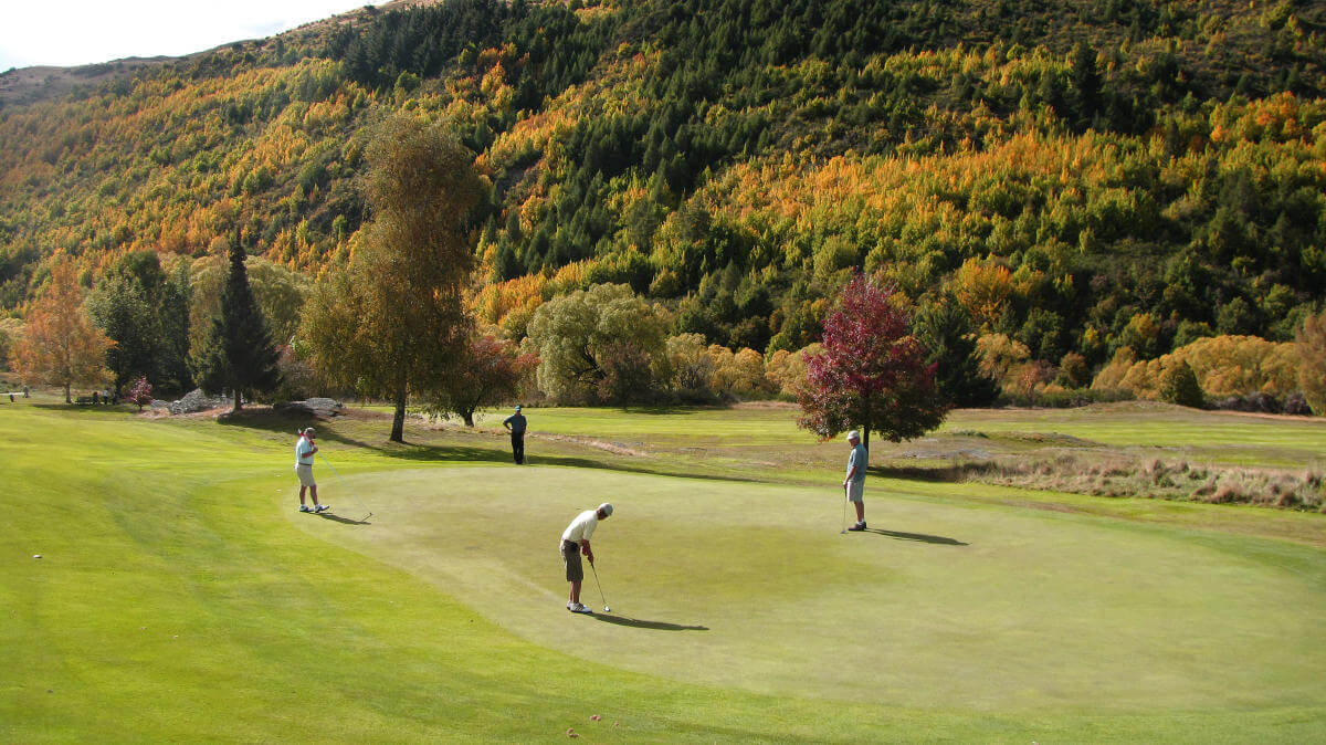 Golfers putt on a green at Arrowtown golf club