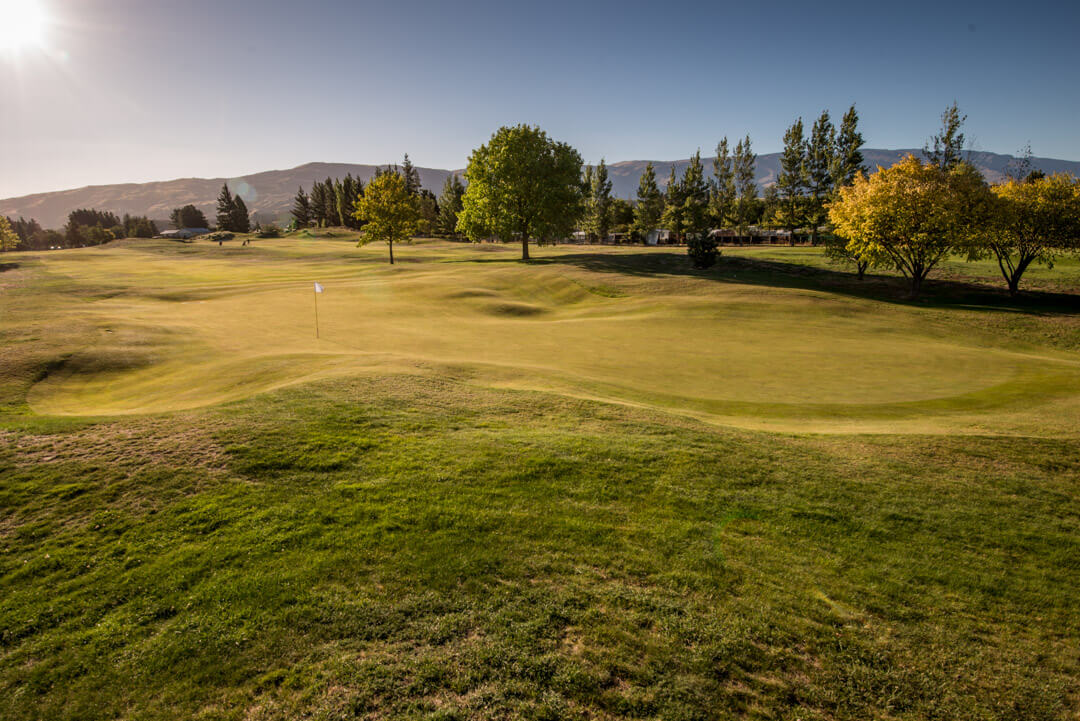 Tenth green and fairway lined with native trees