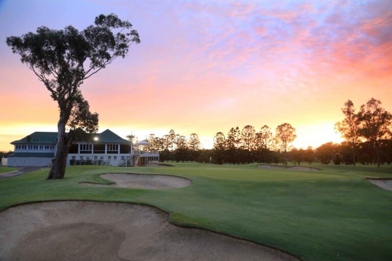 Red sun rises over the golf clubhouse and eighteenth green