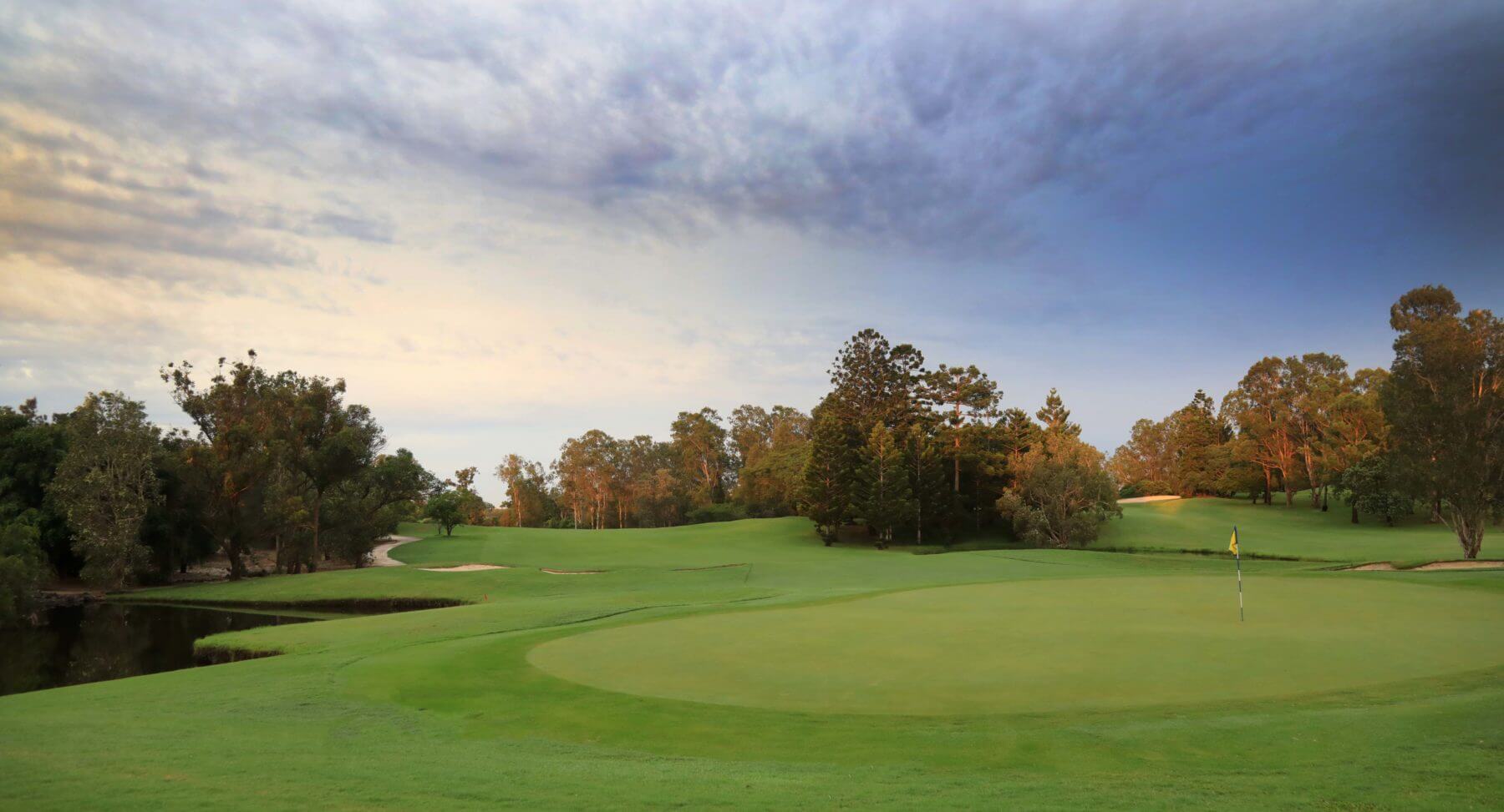 Seventeenth green at dusk with dense native bushland surrounding golf course