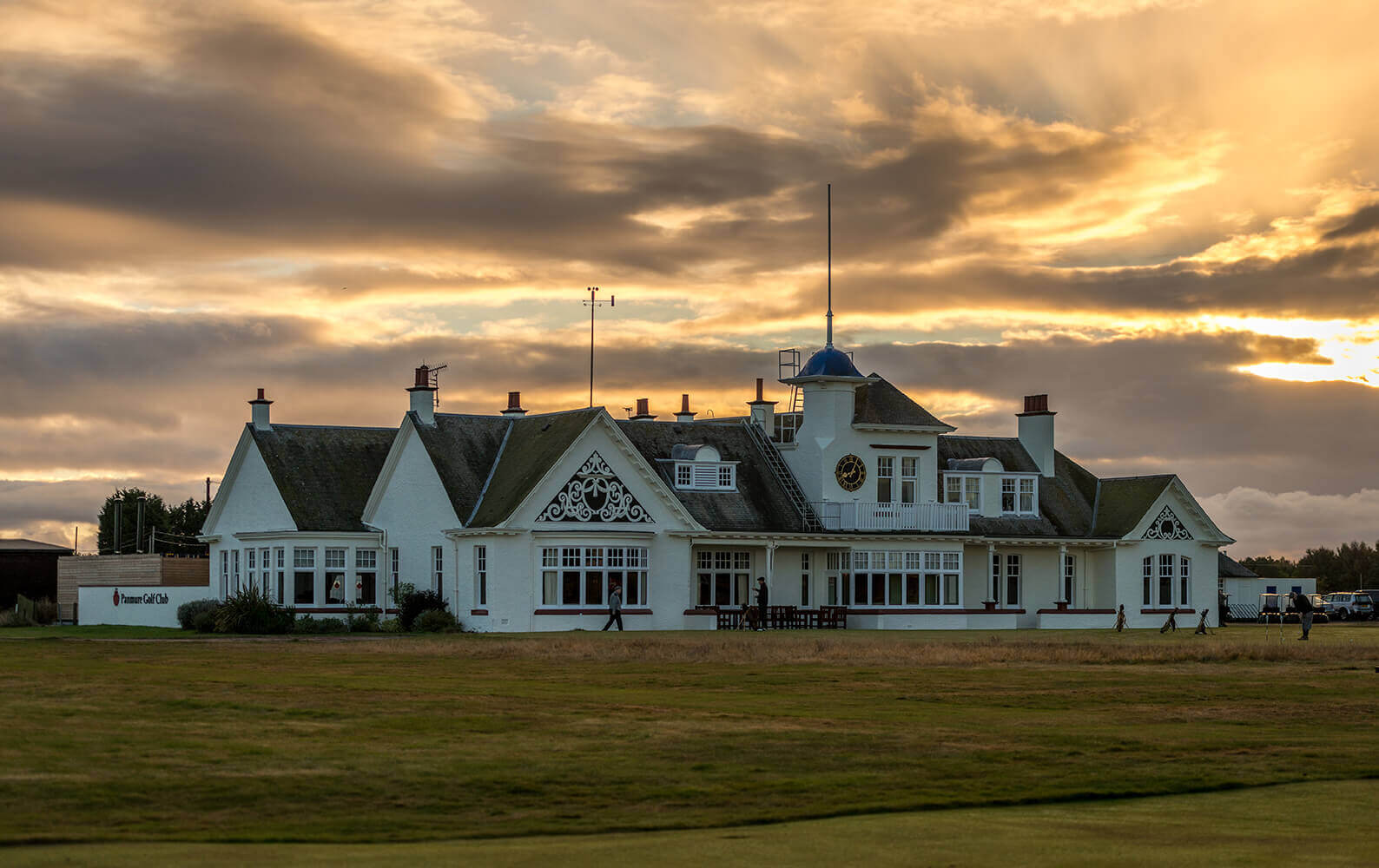 Large clubhouse building stands under orange sky
