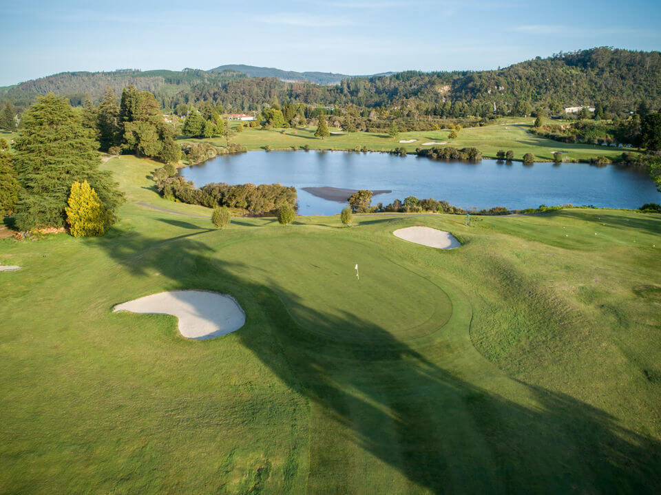 Bunkers protect a green near a lake at Rotorua golf course