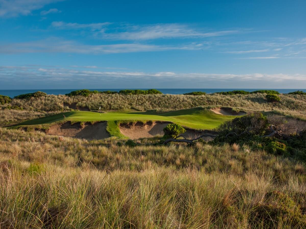 Plateaued green nestled among undulating sand dunes