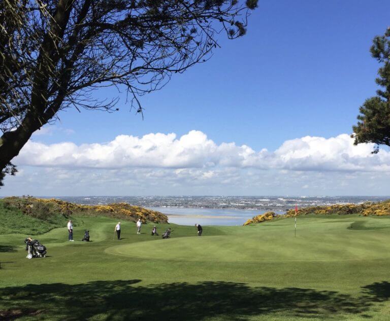 Golfers play Howth Golf Course above Dublin Bay
