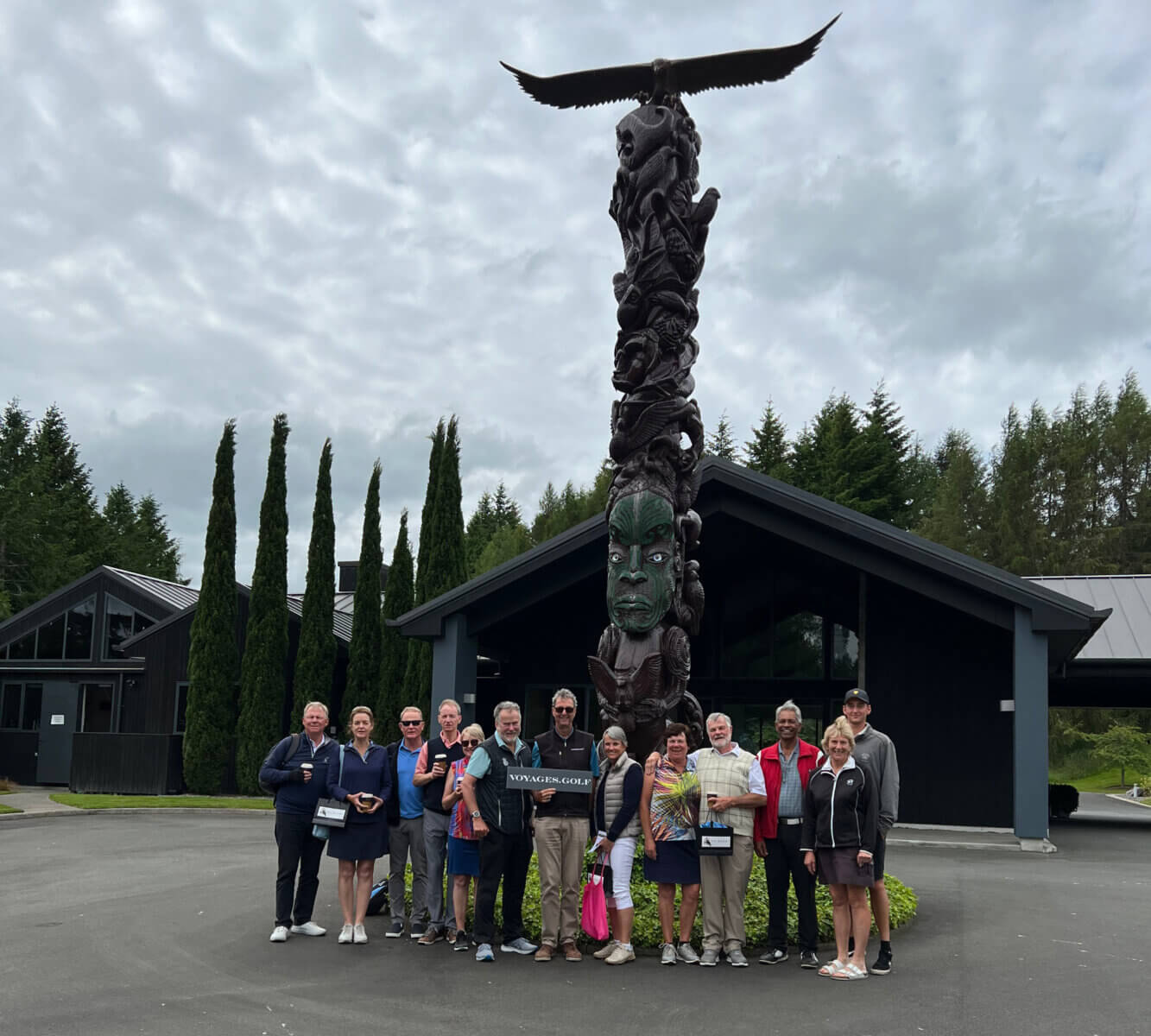 Group of golfers standing in front of Totem Pole