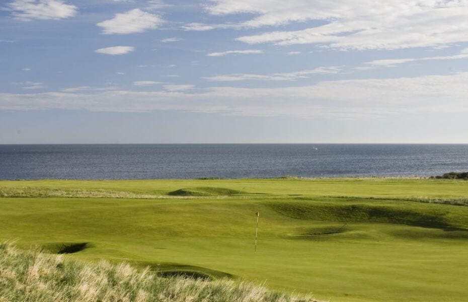 Contrasting fairways and greens with the blue sea and sky at Dunbar Golf Club, Scotland, United Kingdom