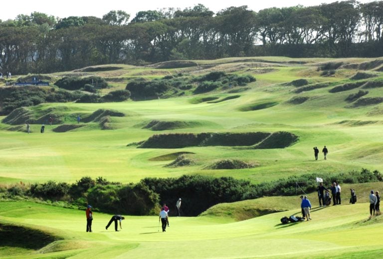 Golfers enjoy the sun and undulating hills at Kingsbarns Golf Links, Scotland, United Kingdom