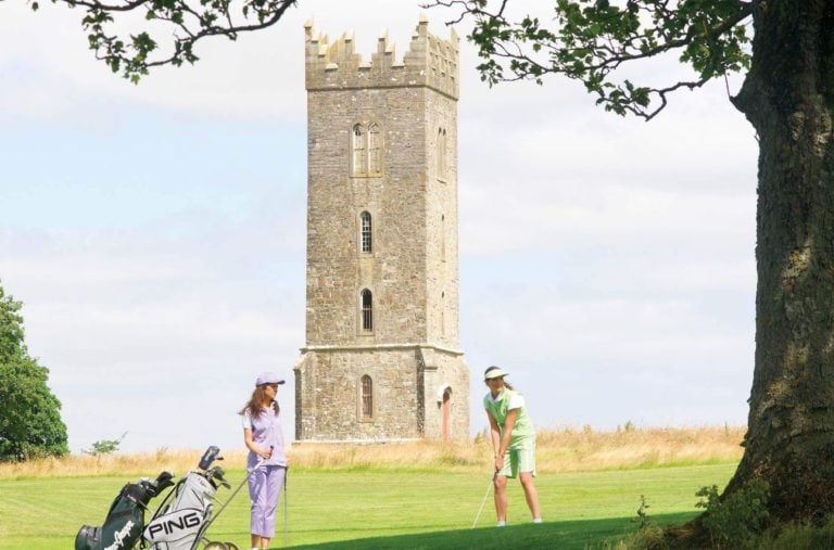 View of ladies playing golf in front of the Tyrconnell Tower on the O'Meara Course, Carton House, Ireland