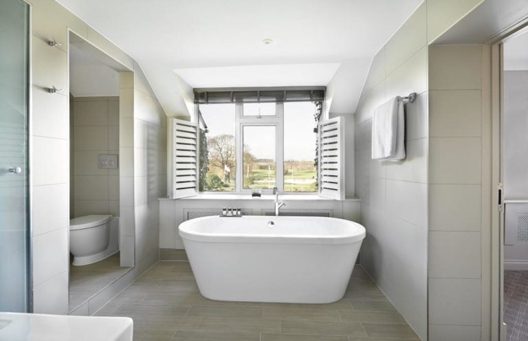 Bathtubs at The Belfry Resort feature shuttered blinds and look over the golf course