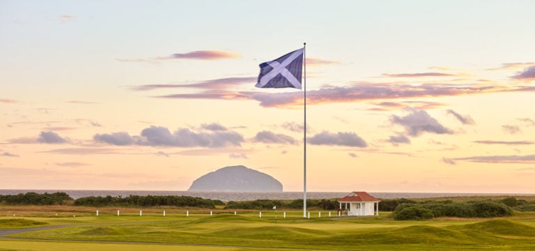 The Scottish flag rises in front of the Ailsa Craig