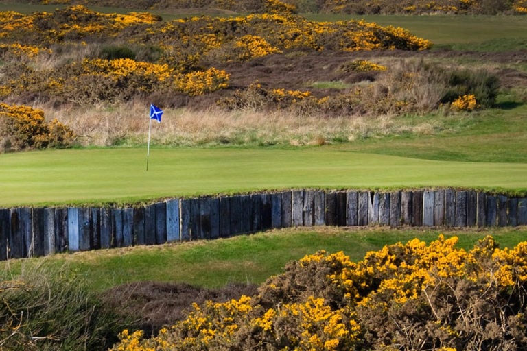 Gorse surrounds a raised green on the 11th at Kilmarnock Barrassie Links, Troon, Scotland, United Kingdom