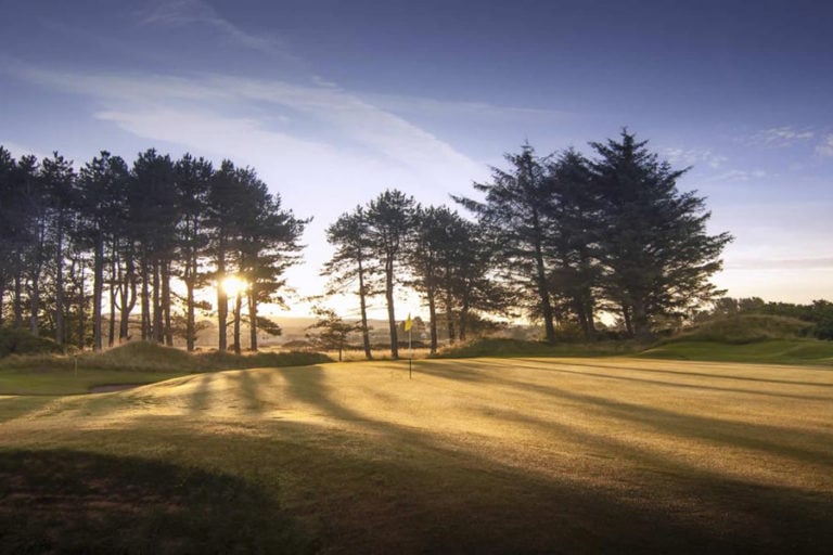 Pine trees surround the green on the 5th at Kilmarnock Barrassie Links, Troon, Scotland, United Kingdom
