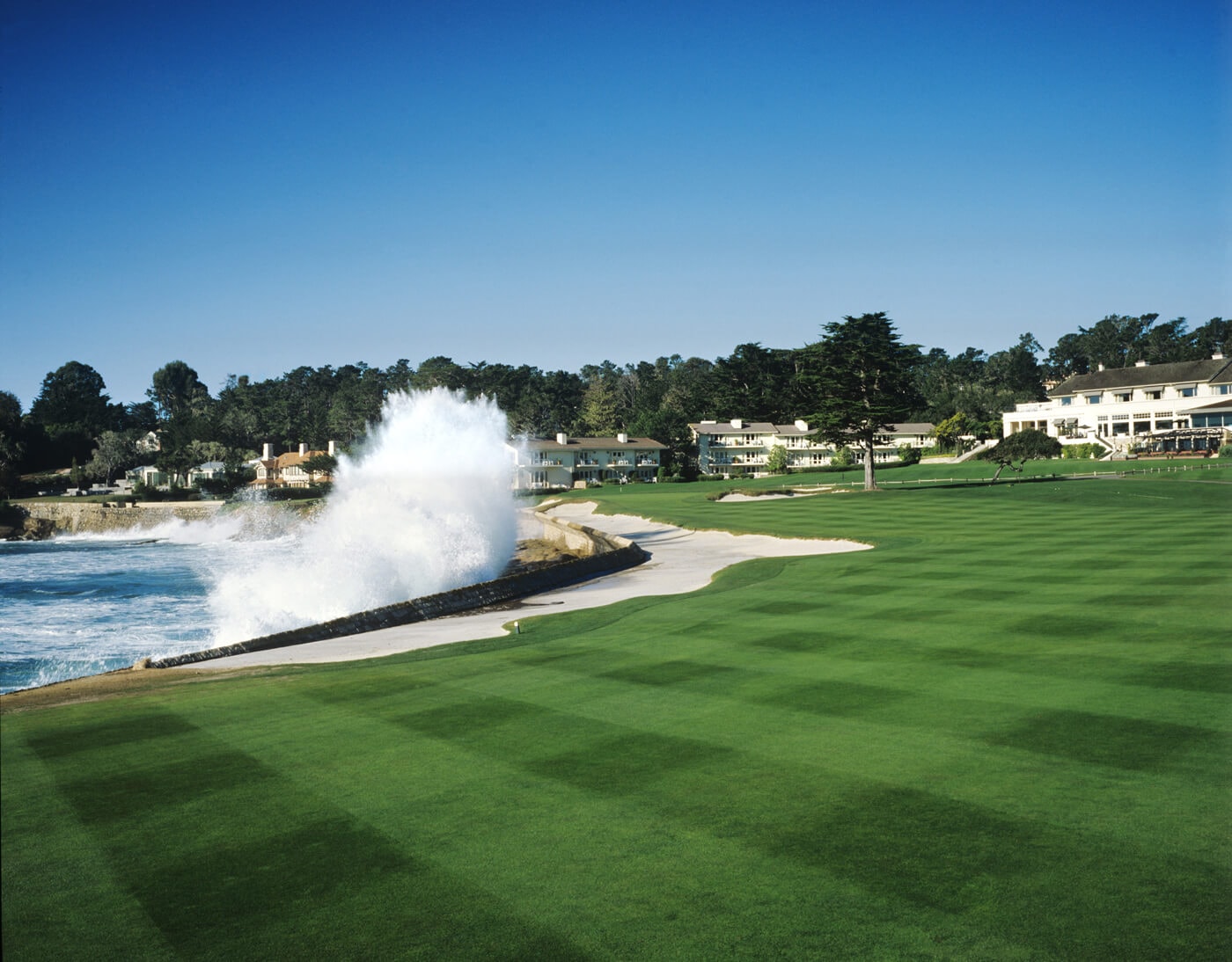 Wave crashes over a bunker on the eighteenth hole at Pebble Beach Golf Links