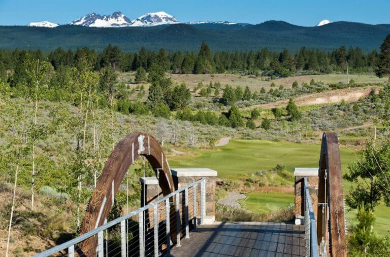 Image of a bridge and distant Cascades mountain range at Tetherow Resort, Bend, Oregon, USA