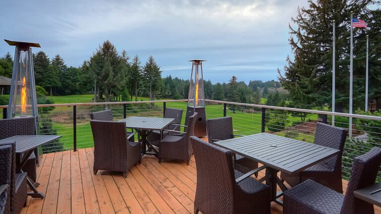 Image of an outdoor patio overlooking the golf course and Pacific Ocean, Salishan Resort, Oregon, USA