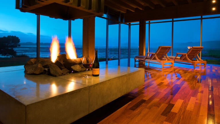 Image of a cost fire and bottle of red wine for two, Salishan Resort, Oregon, USA