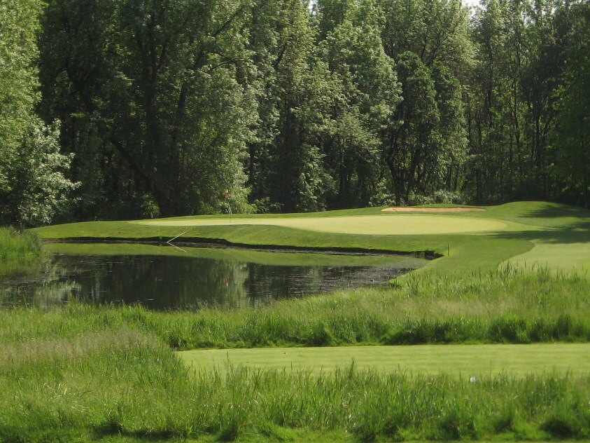 Image of the 12th hole green surrounded by trees and a lake at the Pumpkin Ridge Witch Hollow Golf Course, Oregon, USA