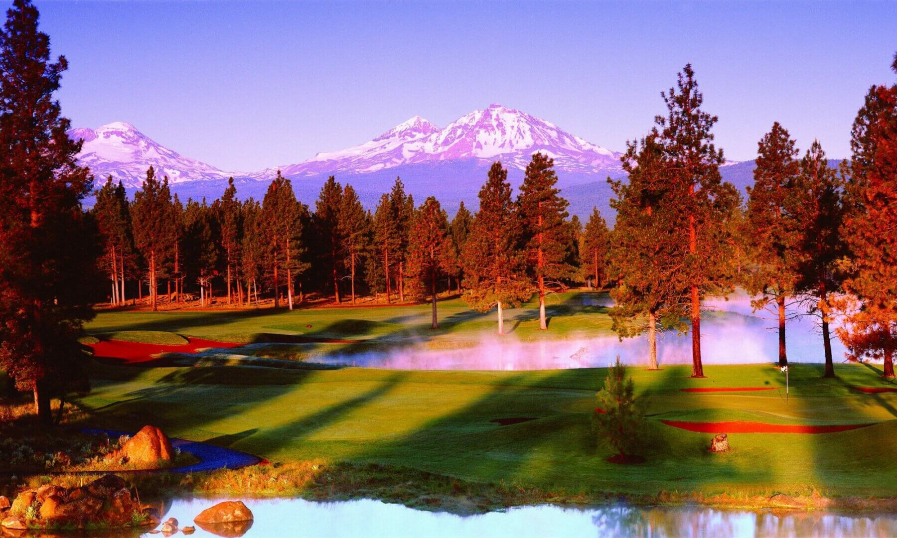 Image of the sun setting over distant hills and the golf course at Aspen Lakes Golf Course, Sisters, Oregon, USA