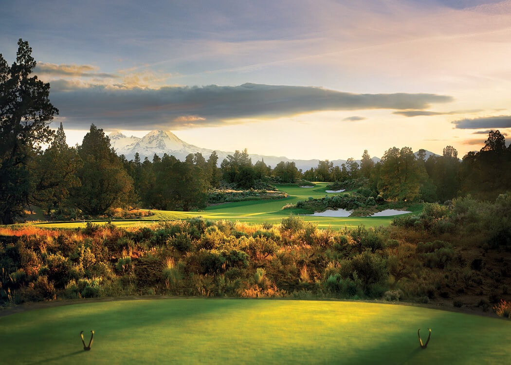 Image of a tee box overlooking a par 3 and distant Cascade mountains on the Jack Nicklaus designed Signature Course at Pronghorn Resort, Bend, Oregon, USA