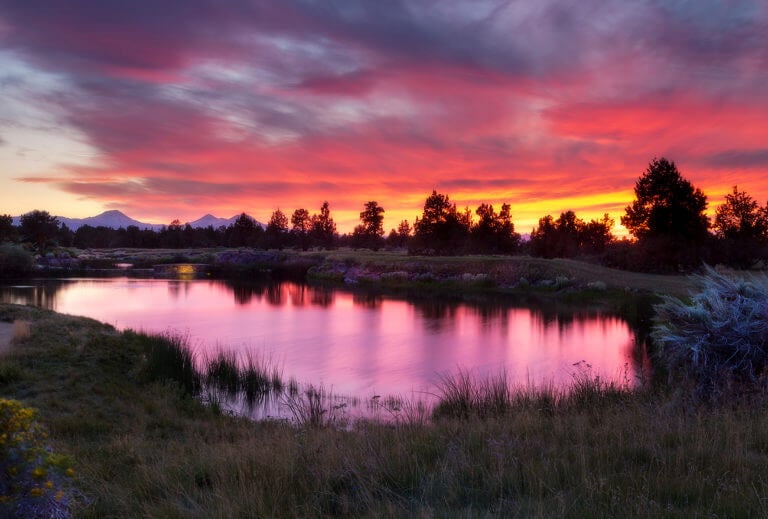 The sun sets over a lake at Pronghorn Golf Resort, Bend, Oregon, USA