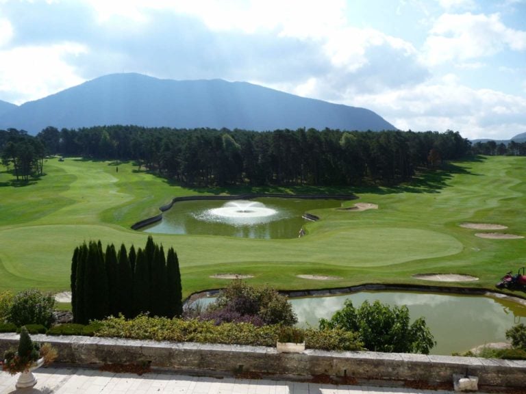 Panoramic views of the 9th and 18th holes surrounded by trees and mountains, Chateau de Taulane, France.