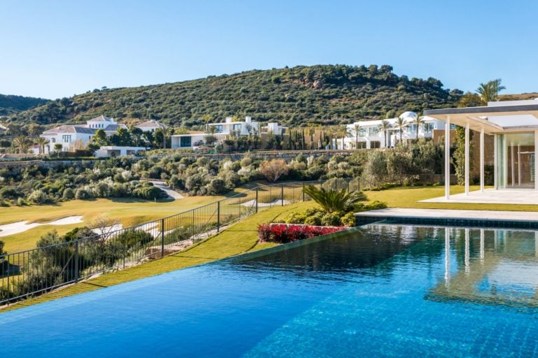 View of the infinity pool overlooking hillside villas