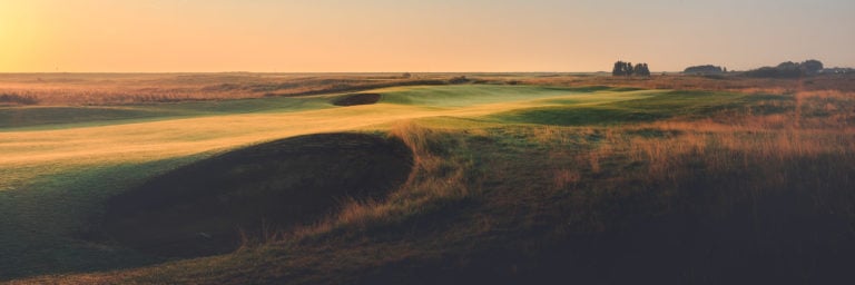 Landscape image of the 12th fairway and large pot bunker at sunset