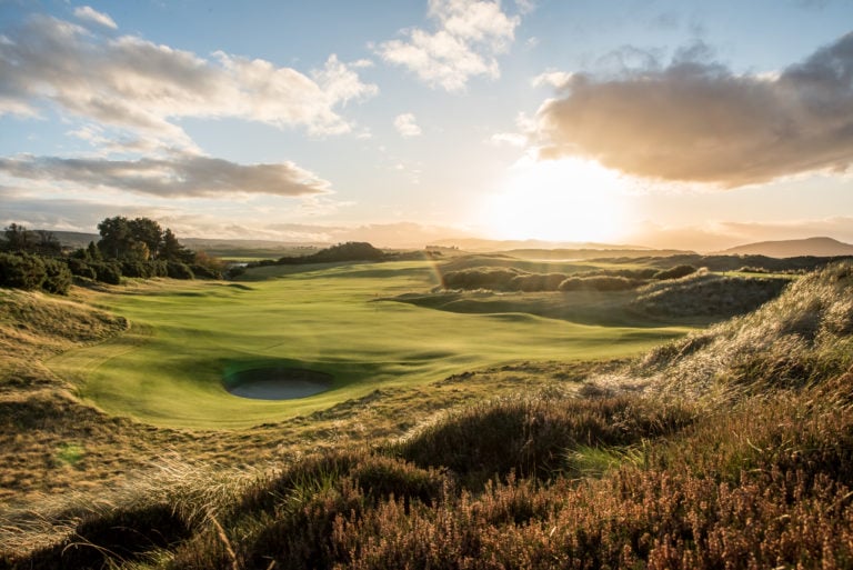 Image depicting the 5th hole with evening light making the sky gold at Castle Stuart Golf Links, Inverness, Scotland