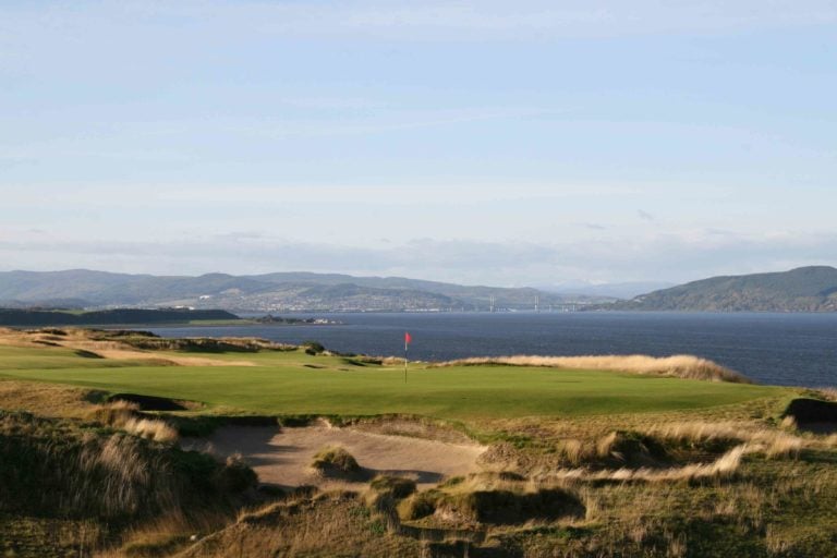 Image overlooking the 16th green and distant waters of the Moray Firth at Castle Stuart Golf Links, Inverness, Scotland