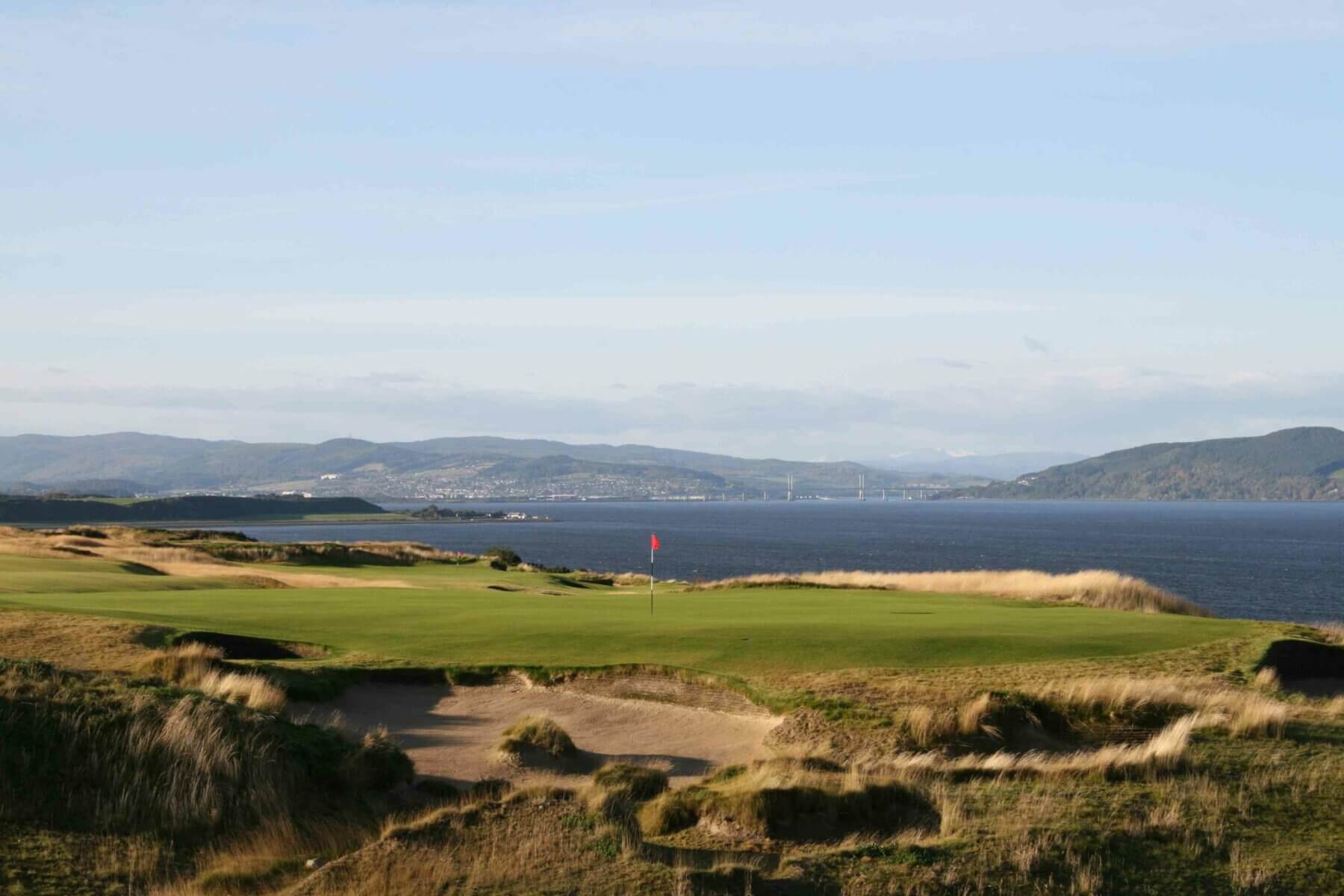 Image overlooking the 16th green and distant waters of the Moray Firth at Castle Stuart Golf Links, Inverness, Scotland