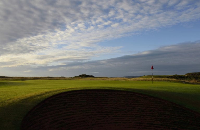 Image of the 15th green and cloudy sky at Royal Dornoch Golf Club, Scotland