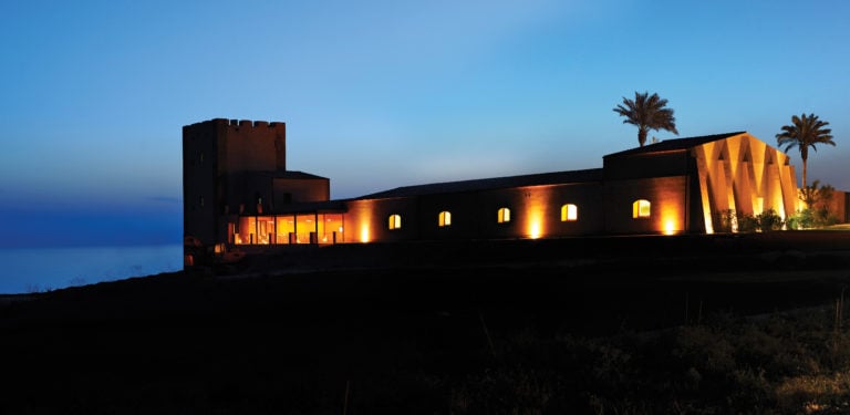Image depicting lights and the silhouette of a resort building at Verdura Resort, Sicily, Italy