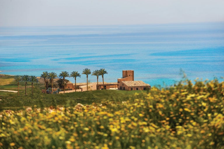 Distant image overlooking the main resort buildings adjacent to the beach, Verdura Resort, Sicily, Italy