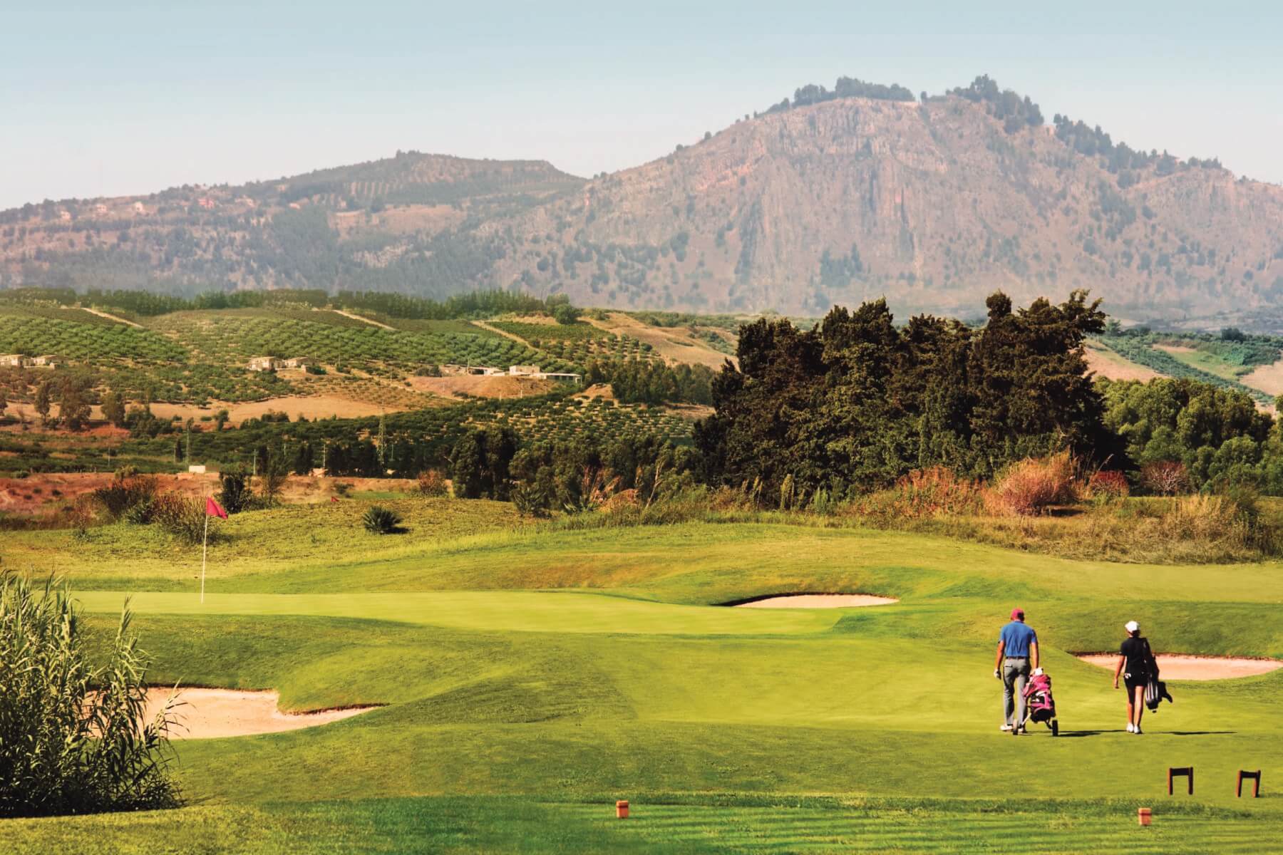 Image of a golfer walking along the golf course at Verdura Resort, Sicily, Italy