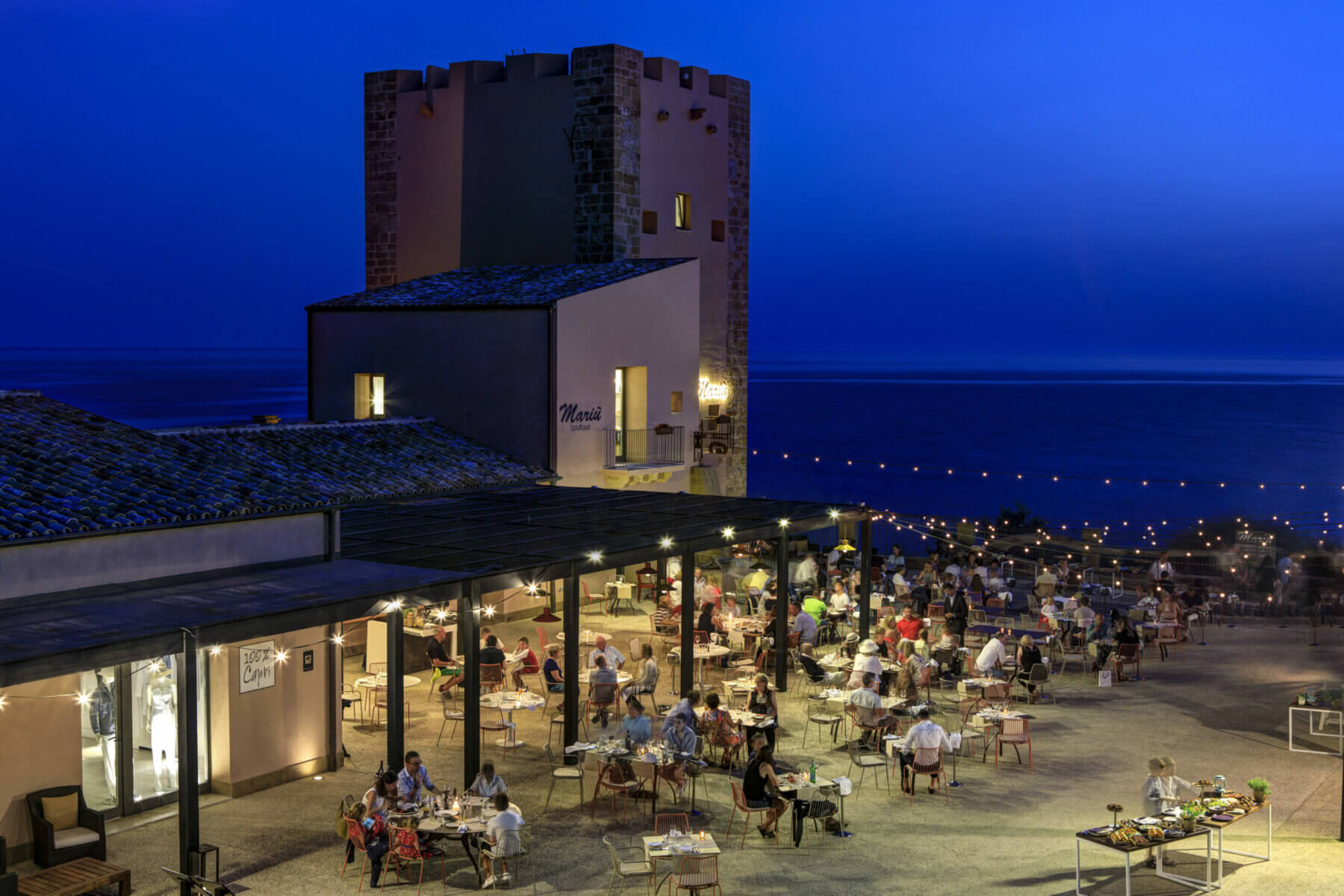 Image depicting diners eating outside in the warm climate at night time at Verdura Resort, Sicily, Italy