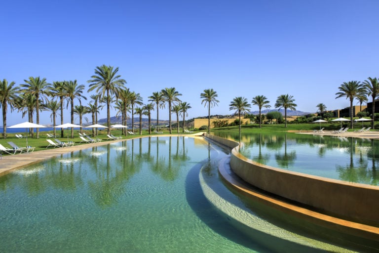 Image of the infinity pool and palm trees at Verdura Resort, Sicily, Italy