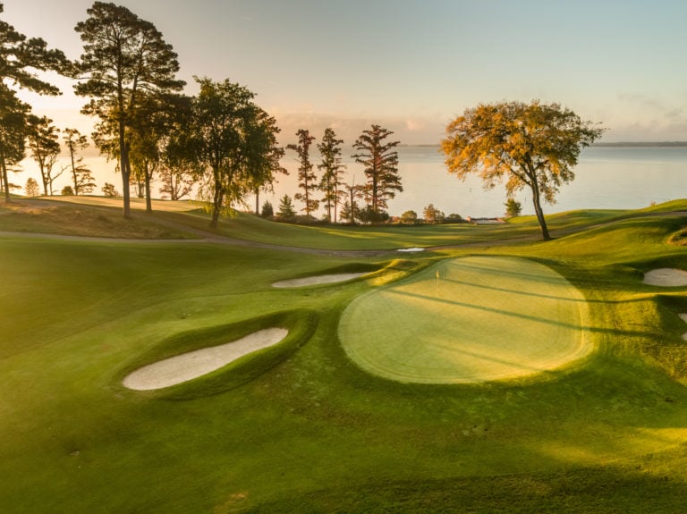 Image depicting the sunshine of dawn rising over the 16th and 17th holes of the River Golf Course at Kingsmill Resort, Williamsburg Virginia, USA