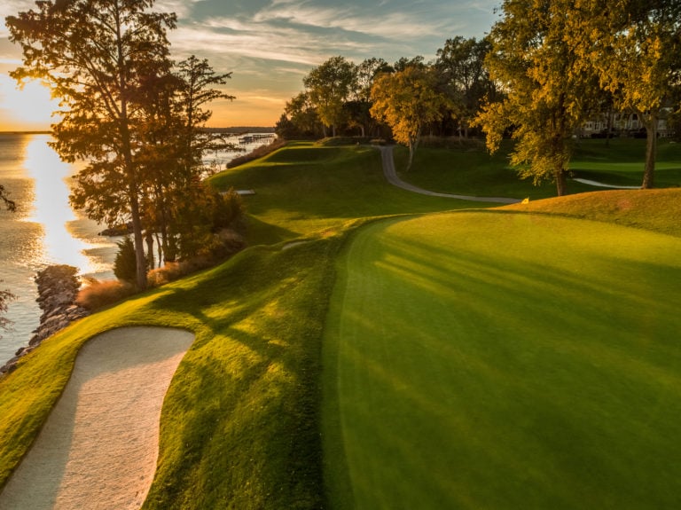 Image depicting the 17th green bathed in orange sunlight on the River Golf Course at Kingsmill Resort, Williamsburg Virginia, USA