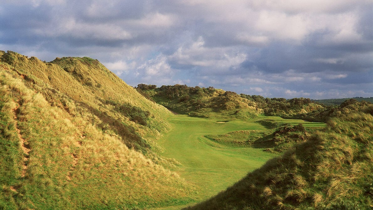 Image displaying a large dune and golf green in the distance at Portsteward Golf Club, Northern Ireland