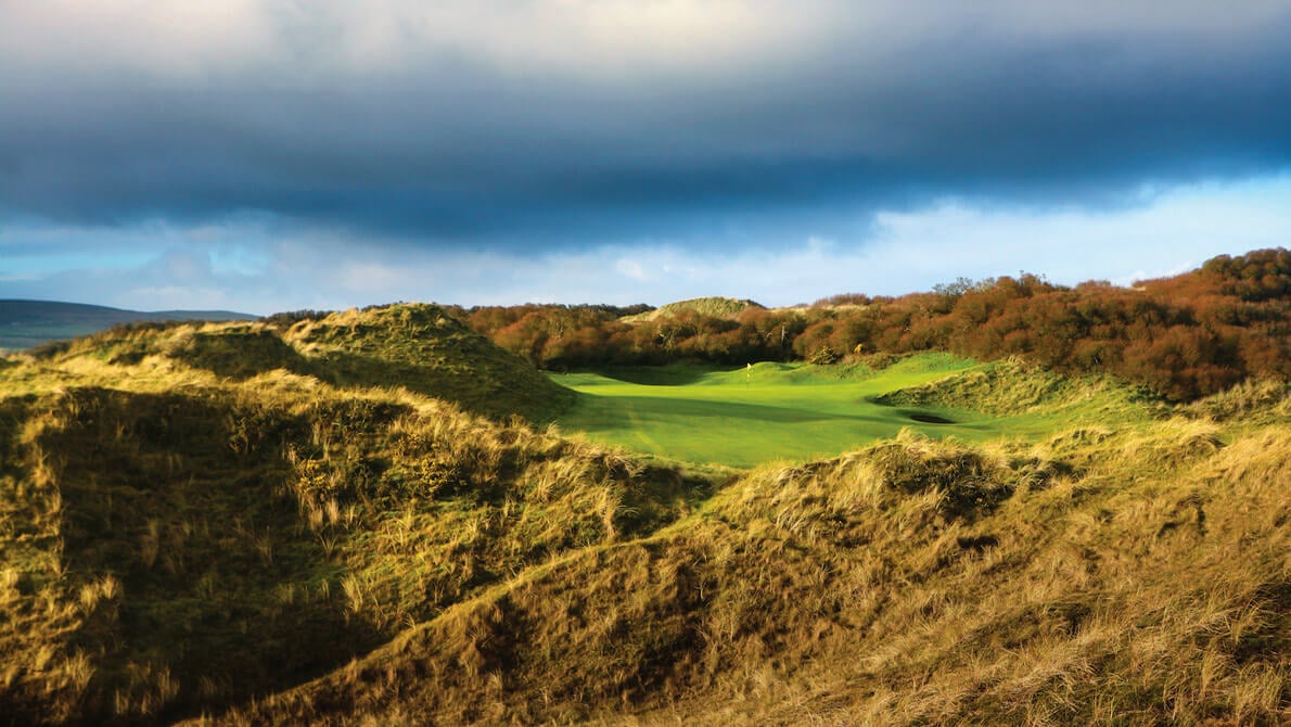 Image displaying wild dunes and a green at Portsteward Golf Club, Northern Ireland