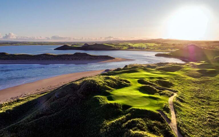 Aerial image overlooking the setting sun over a golf hole at Tralee Golf Club, County Kerry, Ireland