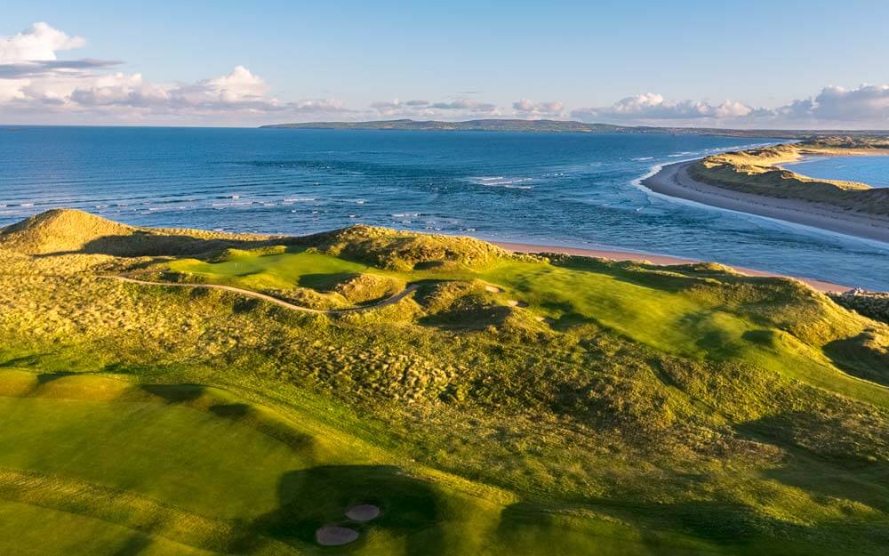 Aerial image of the setting sun bathing the golf course in orange light, Tralee Golf Club, County Kerry, Ireland