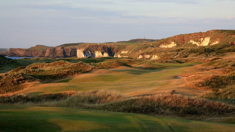 Image depicting the 4th hole and distant white cliffs at Royal Portrush Dunluce Golf Course, Portrush, County Antrim, Northern Ireland